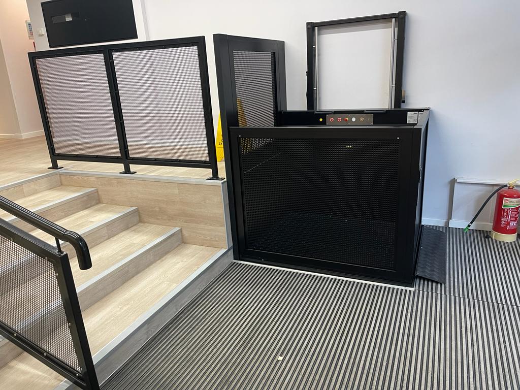 The platform lift has no pit and is fixed to the wall