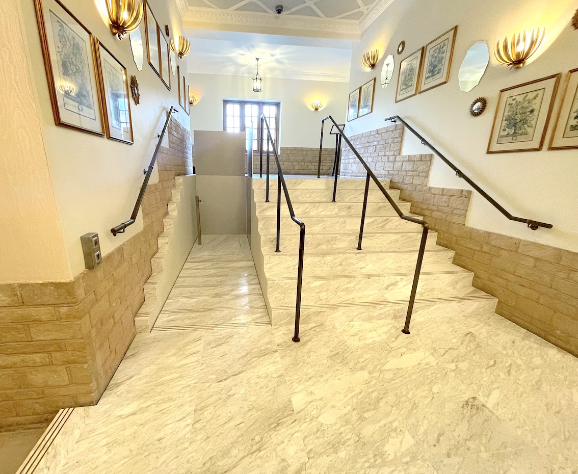 A view from the lower landing of the whole set of white marble steps with the lift in its lowered position